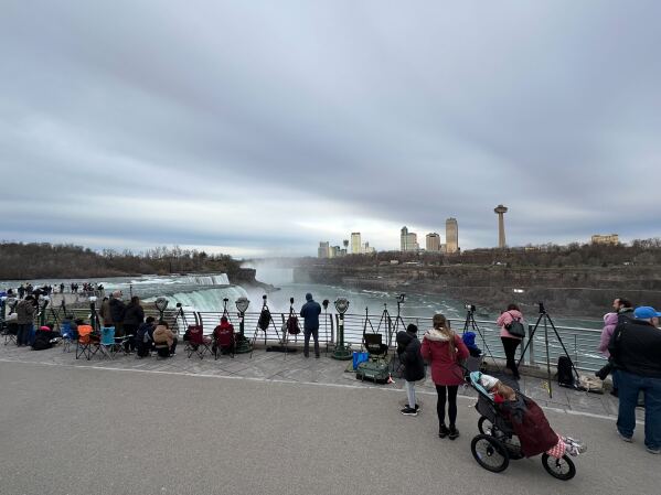 Spectators gather at Niagara Falls under cloudy skies. (AP Photo/David Martin)